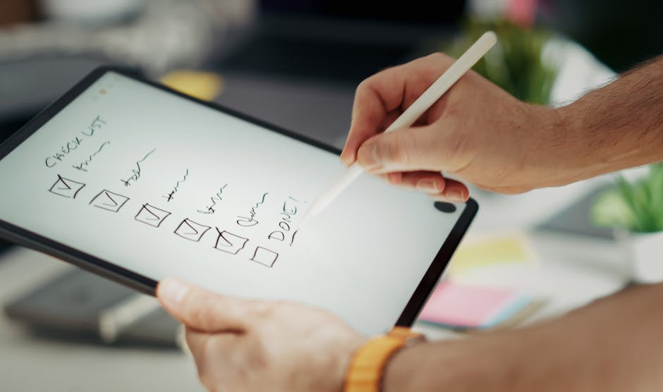 Close-up of a hand writing on a digital checklist using a stylus on a tablet, enhancing productivity.