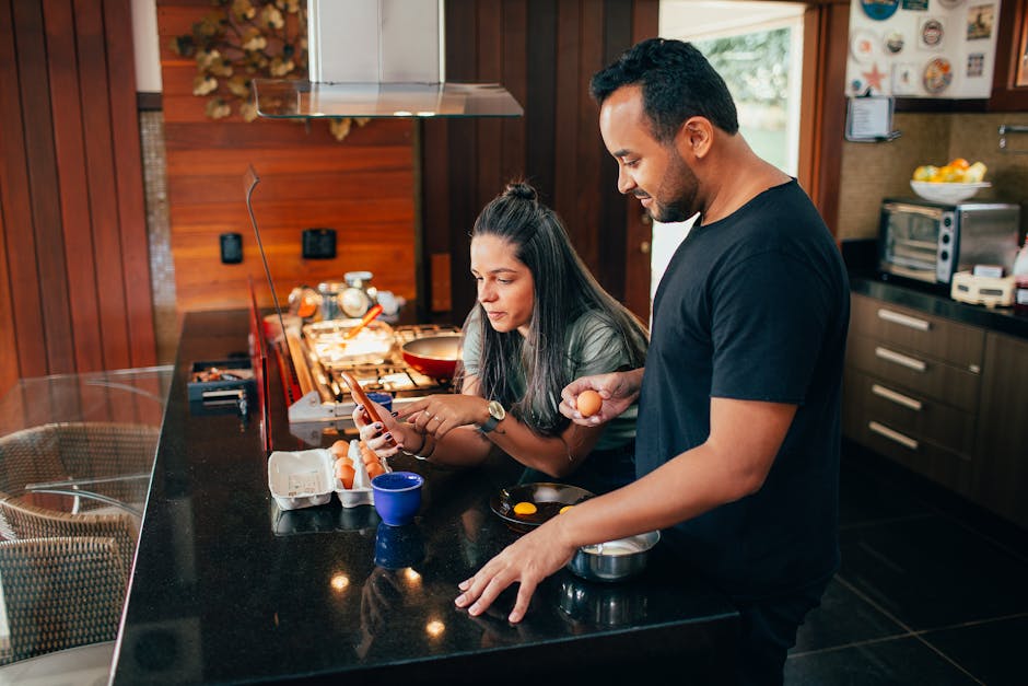 A couple cooking breakfast, sharing a moment at home in a sleek kitchen setting.